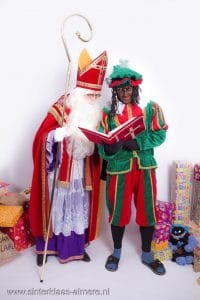 Sint en Piet bestuderen het grote boek van Sinterklaas